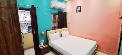 a small bedroom with a bed and a window at Hotel Ananya Inn in Varanasi