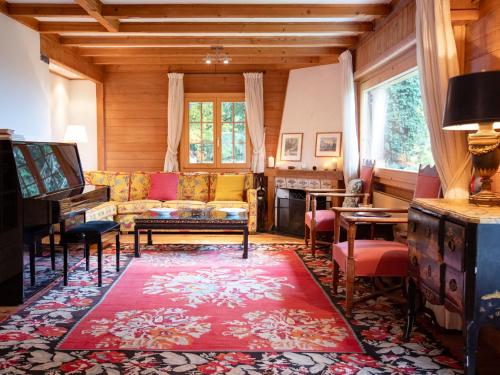 een woonkamer met een bank en een piano bij Chalet Chalet Le Haut Pré by Interhome in Villars-sur-Ollon