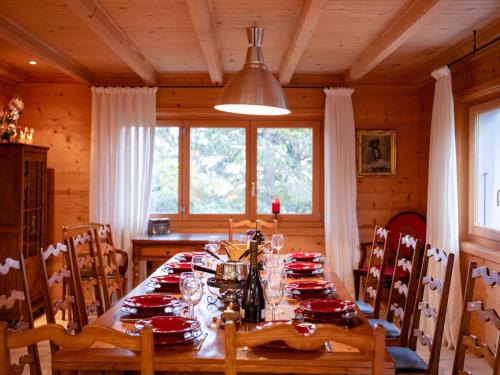 een eetkamer met een tafel met rode gerechten erop bij Chalet Chalet Le Haut Pré by Interhome in Villars-sur-Ollon