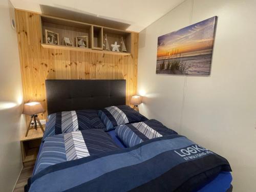 Schlafzimmer mit einem Bett mit einer blauen und weißen Bettdecke in der Unterkunft Holiday Home Alex by Interhome in Wemding