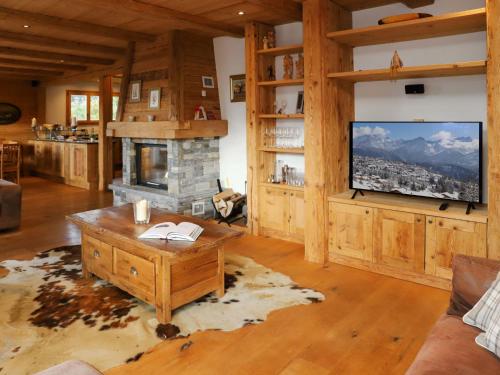 a living room with a fireplace and a flat screen tv at Chalet Chalet Picoulet by Interhome in Villars-sur-Ollon