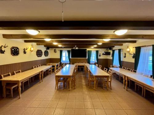 jadalnia ze stołami i krzesłami oraz telewizorem w obiekcie Holiday Home Mazurova chalupa by Interhome w mieście Býšť