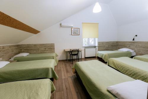 ヴィーンヌィツャにあるSmart Apartのベッド4台とテーブルが備わる客室です。