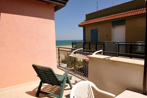 マルゲリータ・ディ・サヴォイアにあるLa Perla delle Salineのビーチ付きのバルコニー(緑の椅子、椅子2脚付)