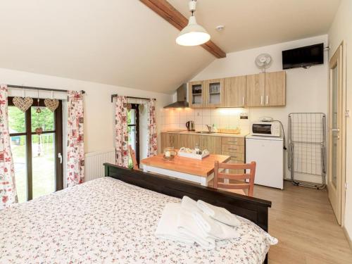 ein Schlafzimmer mit einem Bett und eine Küche mit einem Tisch in der Unterkunft Apartment Arnoltice 5 by Interhome in Arnoltice u Decina