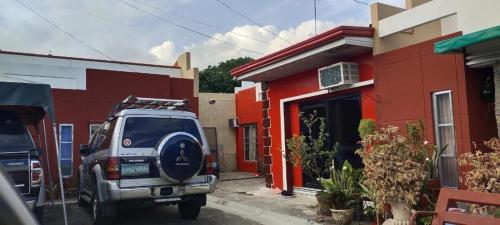 a suv parked in front of a red building at RB Modern Condos in Zamboanga