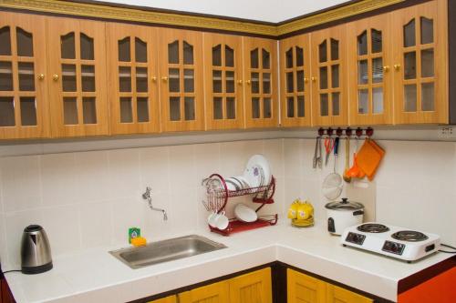 a kitchen with wooden cabinets and a sink at RB Modern Condos in Zamboanga