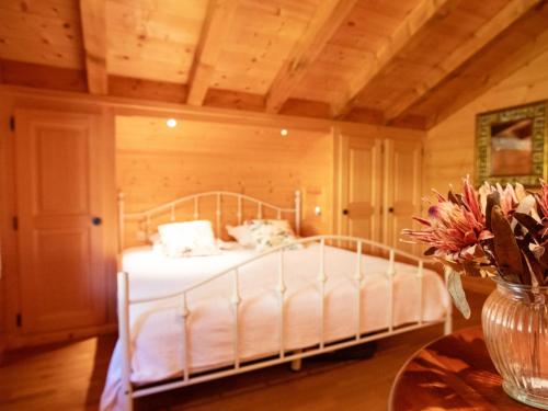a bedroom with a bed with white sheets and a table at Apartment La-Ina by Interhome in Chesières