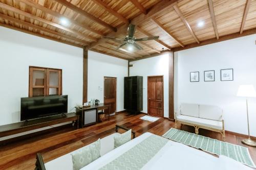 a living room with a couch and a television at Maison Barn Laos in Luang Prabang