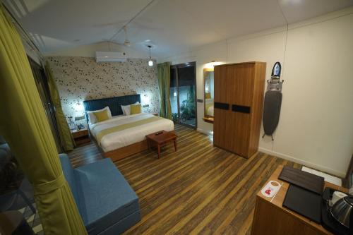 ein Schlafzimmer mit einem Bett und einem Sofa in einem Zimmer in der Unterkunft SKD RESORT AND CLUB 