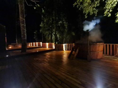 a wooden deck at night with a barrel at Espectacular y Amplia Casa en Reserva Huilo Huilo in Huilo Huilo