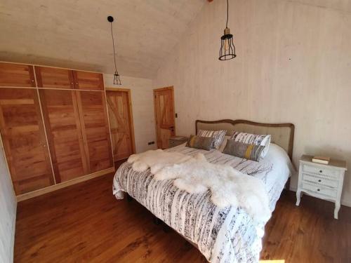 a bedroom with a bed and a wooden floor at Espectacular y Amplia Casa en Reserva Huilo Huilo in Huilo Huilo