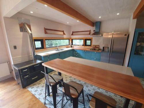 a kitchen with blue cabinets and a wooden counter top at Espectacular y Amplia Casa en Reserva Huilo Huilo in Huilo Huilo