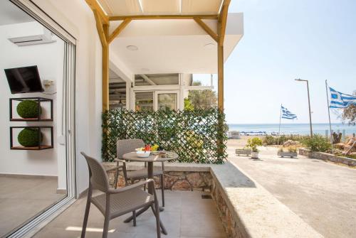 um pátio com uma mesa e cadeiras e vista para o oceano em Marini Seaside em Faliraki