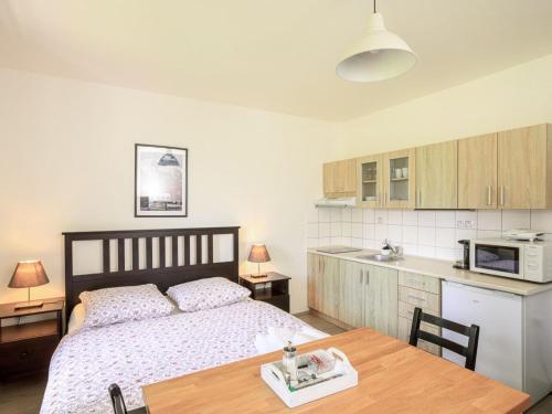 1 dormitorio con cama, mesa y microondas en Apartment Arnoltice 1 by Interhome, en Arnoltice u Decina