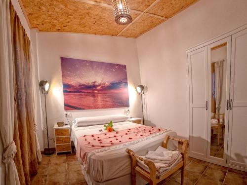 a bedroom with a bed with a painting on the wall at Holiday Home La Cascada by Interhome in Rute