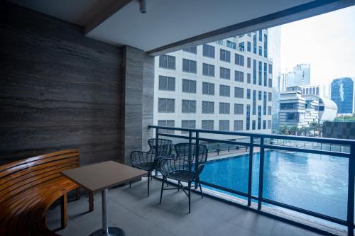 a balcony with a table and chairs and a pool at Studio with Netflix, 55in TV, 200Mbs net, in heart of Makati in Manila