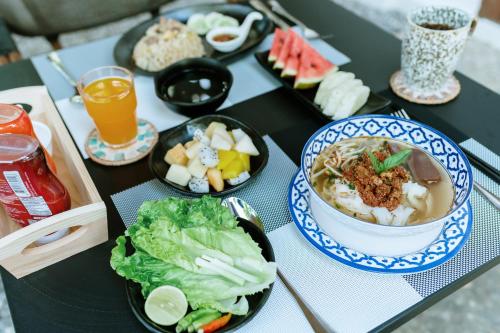 ルアンパバーンにあるMaison Barn Laosの食べ物と飲み物を盛り付けたテーブル