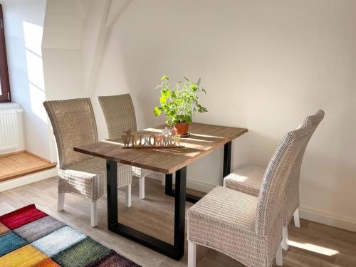 een eettafel met stoelen en een plant erop bij Apartment Salzmännchen by Interhome in Zittau