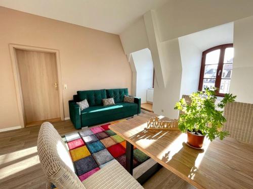 een woonkamer met een groene bank en een tafel bij Apartment Salzmännchen by Interhome in Zittau