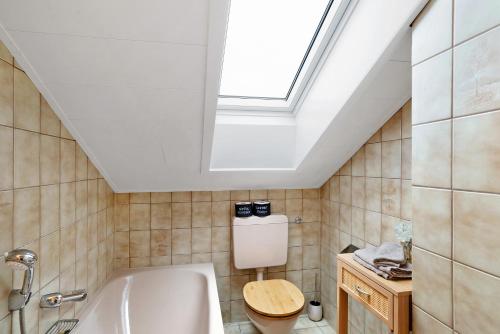 a bathroom with a skylight and a toilet and a tub at Schwarzwaldtani - Dörfle in Ottersweier