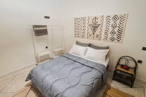 1 dormitorio con 1 cama y una foto en la pared en Tambarkiyt House Studio Appartement - Aourir Agadir en Agadir