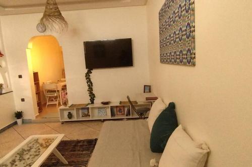 sala de estar con sofá y TV de pantalla plana en Tambarkiyt House Studio Appartement - Aourir Agadir en Agadir