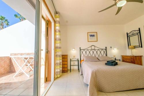 una camera da letto con un letto e un balcone di Parque Santiago II Villa 2 Tenerife Rental & Sales a Playa de las Americas
