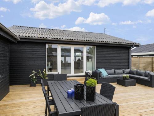 a patio with a table and a couch at Holiday Home Elisabeta - 60m from the sea in SE Jutland by Interhome in Juelsminde