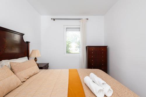 a bedroom with a bed with two towels on it at Olivais Vintage by Homing in Lisbon