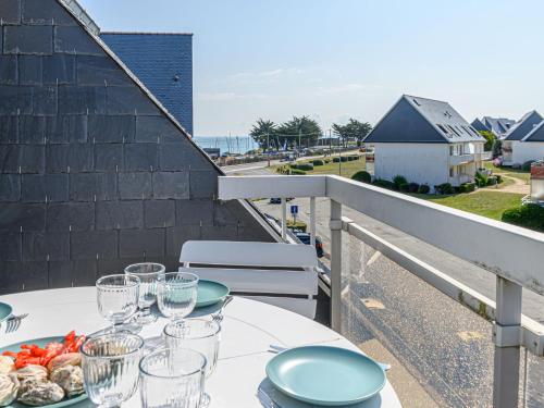 une table blanche avec des verres et de la nourriture sur un balcon dans l'établissement Apartment Les Cardinaux by Interhome, à Quiberon