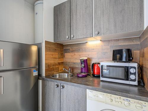 une cuisine avec un micro-ondes et un évier dans l'établissement Apartment Les Cardinaux by Interhome, à Quiberon