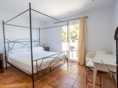 a bedroom with a four poster bed and a desk at Villa Villa Finesse Villas 3 dorm by Interhome in Son Bou