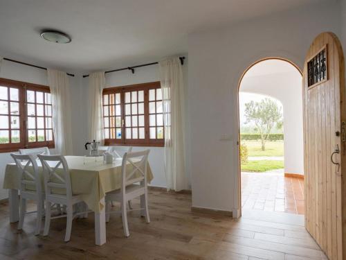 a dining room with a table and chairs and an archway at Apartment Son Bou Gardens Apt 3 dorm by Interhome in Son Bou