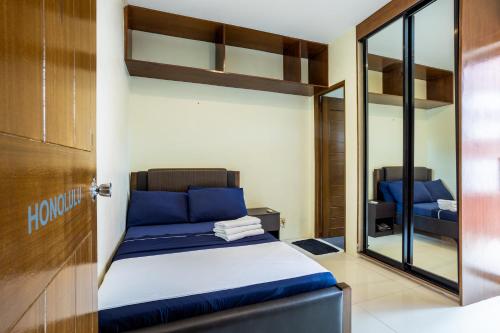 1 dormitorio con cama con almohadas azules y espejo en Home Near Airport & MOA for Big Family Groups, en Manila