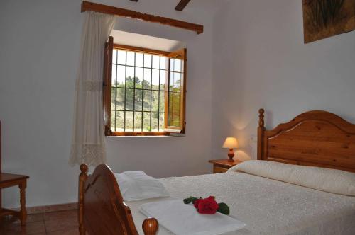 um quarto com uma cama e uma janela em Casa rural El Salero Piscina campo de fútbol y voley chimenea barbacoa em Moratalla