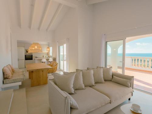 ein Wohnzimmer mit einem Sofa und Meerblick in der Unterkunft Holiday Home Son Bou Sunset 49 by Interhome in Alaior