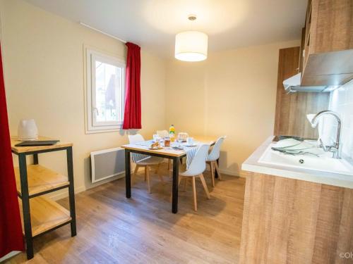 a kitchen with a table with chairs and a sink at Apartment Les Hameaux de la Perrière-1 by Interhome in Saint-Colomban-des-Villards