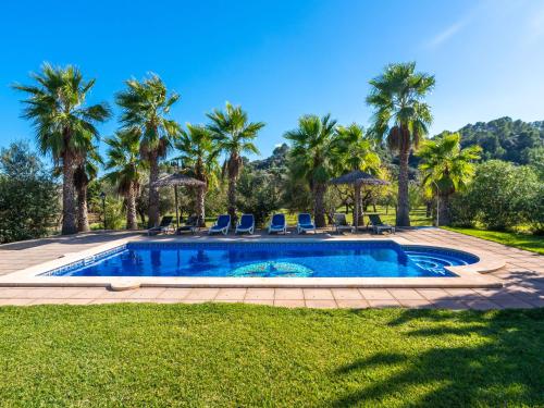 uma piscina num quintal com palmeiras em Villa Can Mestre by Interhome em Selva