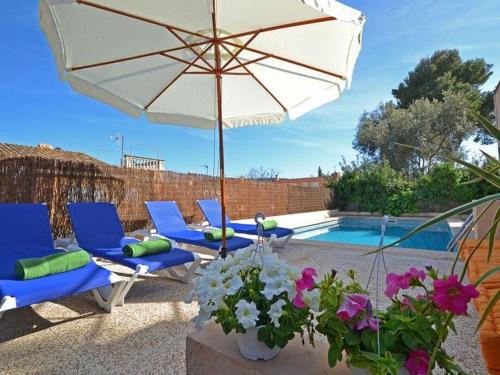 a patio with chairs and an umbrella and a pool at Villa Benestar by Interhome in El Toro