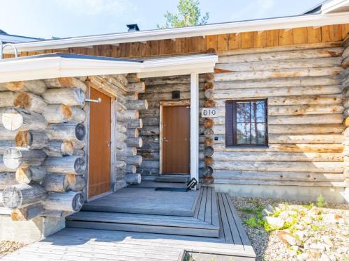 uma cabana de madeira com um alpendre e uma porta em Holiday Home Nilikuru d10 by Interhome em Saariselka