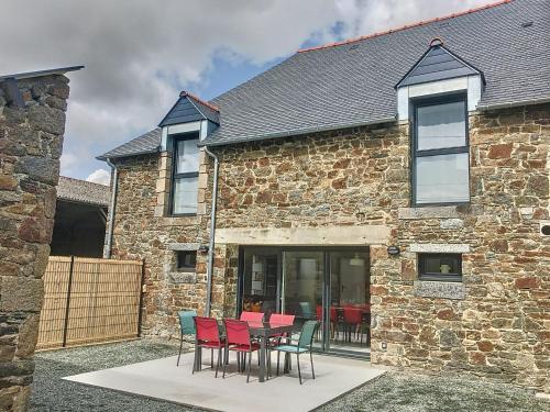 une table et des chaises devant un bâtiment en briques dans l'établissement Holiday Home Le cottage by Interhome, à La Fresnais