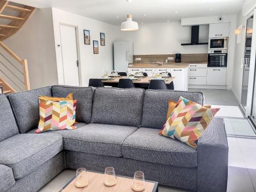 un salon avec un canapé et une cuisine dans l'établissement Holiday Home Le cottage by Interhome, à La Fresnais