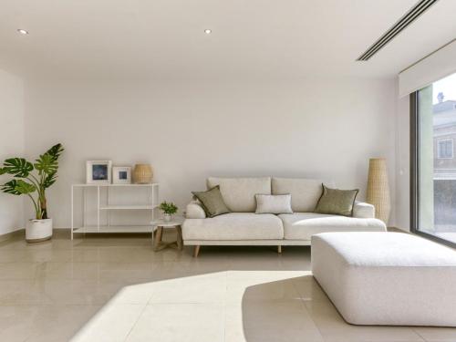 sala de estar blanca con sofá y ventana en Holiday Home Lizarran by Interhome, en Figueres