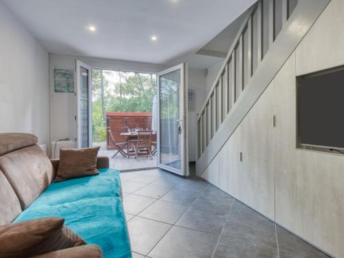 un salon avec un canapé et une télévision dans l'établissement Holiday Home Les Landaises-12 by Interhome, à Lacanau