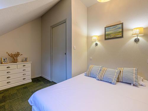 une chambre avec un lit blanc et une commode dans l'établissement Villa Château De Kergonano- dans l'Orangerie-4 by Interhome, à Baden