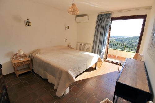 a bedroom with a bed and a large window at Villa La Vista in Calonge