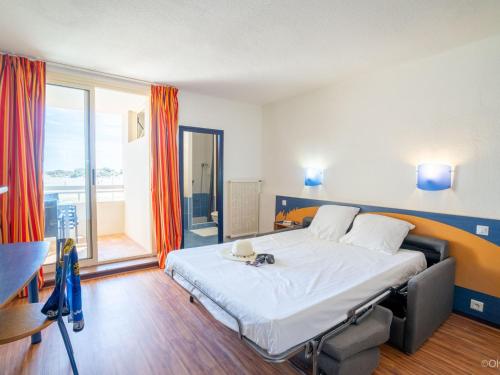 une chambre avec un grand lit avec une grande fenêtre dans l'établissement Studio Le Neptune-2 by Interhome, à Saint Pierre La Mer