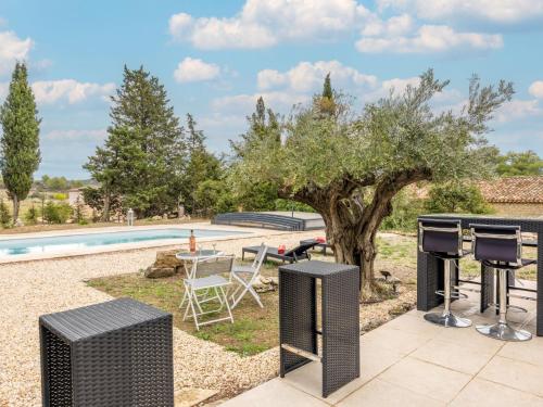 un patio avec une table et des chaises à côté d'une piscine dans l'établissement Holiday Home La Pinède by Interhome, à Azillanet