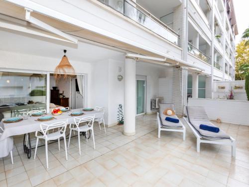 um pátio com uma mesa branca e cadeiras em Apartment Nautic-2 by Interhome em Platja d'Aro
